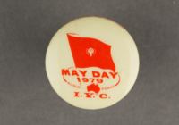 A white badge with red print with the words May Day.
