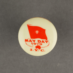 A white badge with red print with the words May Day.