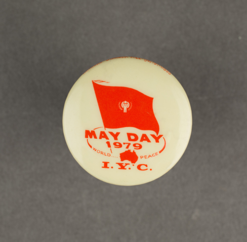 A white badge with red print with the words May Day.