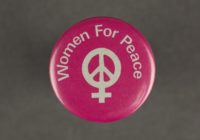 Hot pink badge with a while peace sign displayed in the centre. The words 'women for peach' in displayed arched over the top of the peace sign.