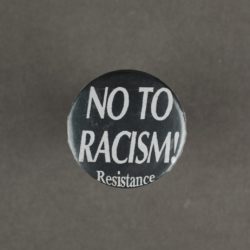 A black badge with white text that says 'no to racism! resistance'