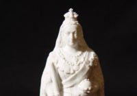 A small statue of queen Victoria in white ceramic.