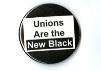 A black badge with a white square in the center. In the square is the phrase Unions are the New Black.